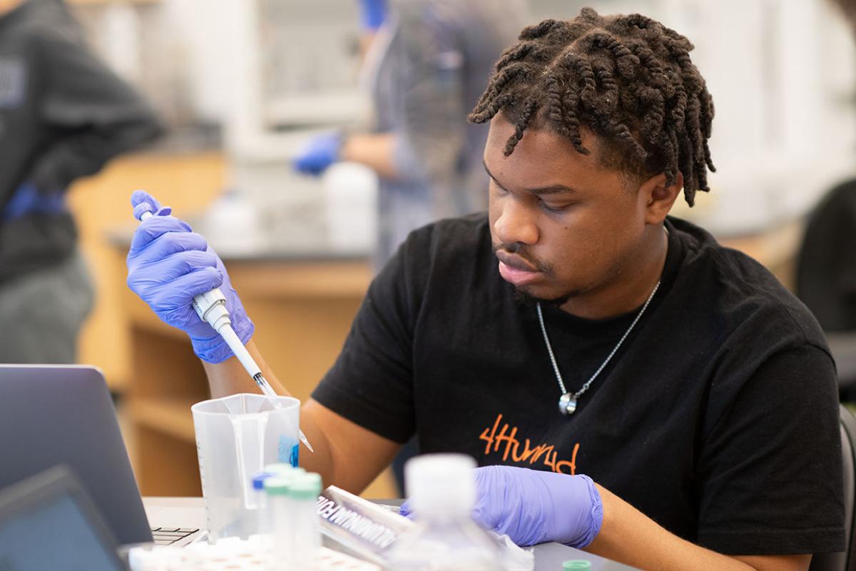 A biology major at Westfield State University conducts an experiment during class in a science lab.