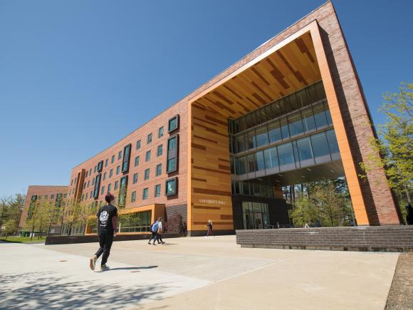 Exterior view of University Hall with students walking in the foreground