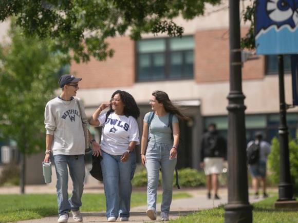 Three students walking on campus together.