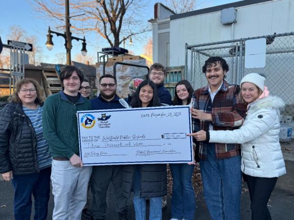 Students in the Student Government Association (SGA) holding up a big check for $3,000, which they raised for the 2024 annual turkey drive for Thanksgiving.