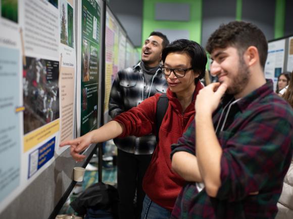 Two students looking at a poster during the CURCA undergraduate research event.