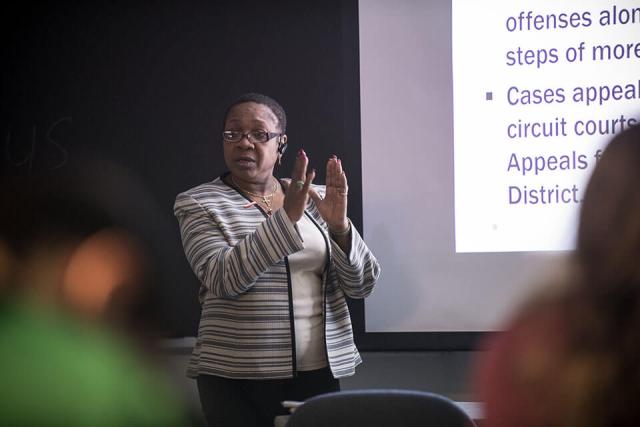 A professor teaching students in a classroom setting.