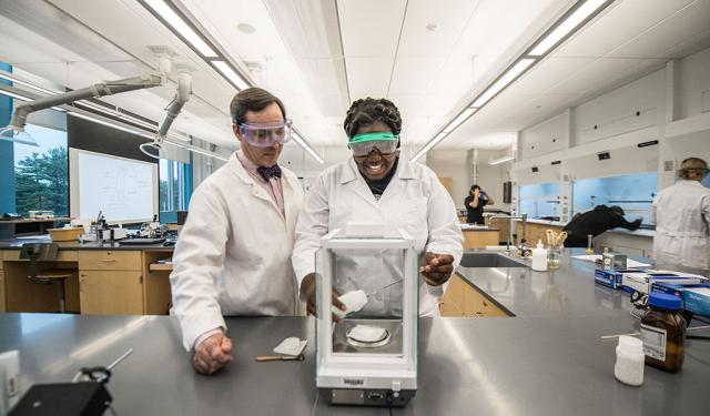 Multiple students and their professor work in a laboratory.