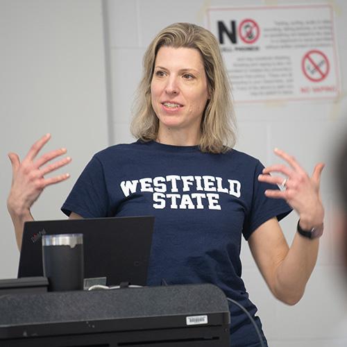 Economics Department Chair Dr. Susanne Chuku stands at the front of a classroom while teaching.