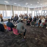 A crowd of students sitting on opposite sides of the room in rows, as part of Discover's Westfield's Shark Tank event.