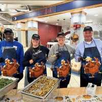 The 2024 Thanksgiving turkey dinner at the Dining Commons. Volunteers in turkey aprons service food to students, faculty, and staff.